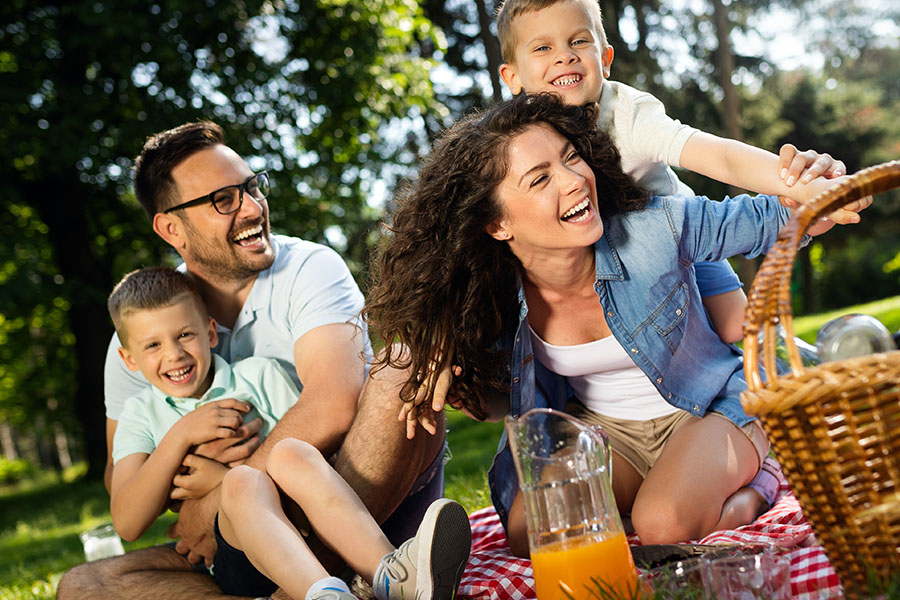 Personal Insurance - Cheerful Happy Family Picnicking on a Beautiful Day